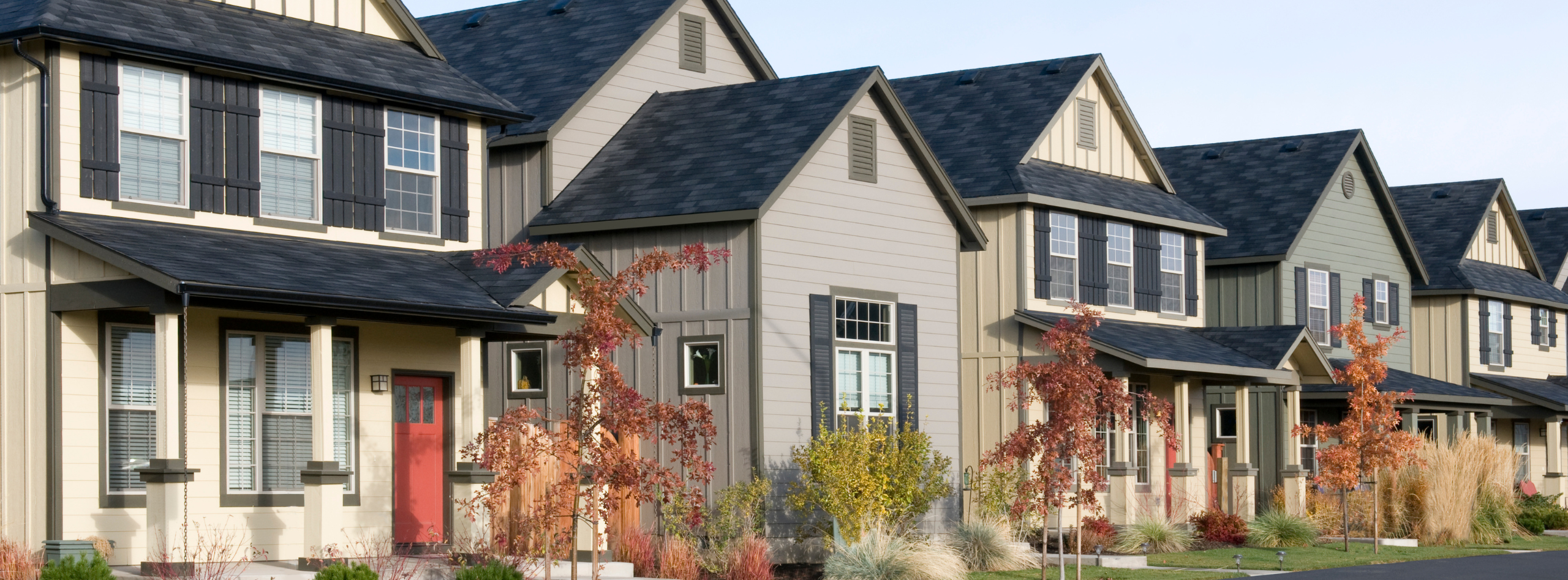 A row of modern BC houses with fall landscaping, representing typical residential homes that benefit from BC house insurance through Westland Insurance.